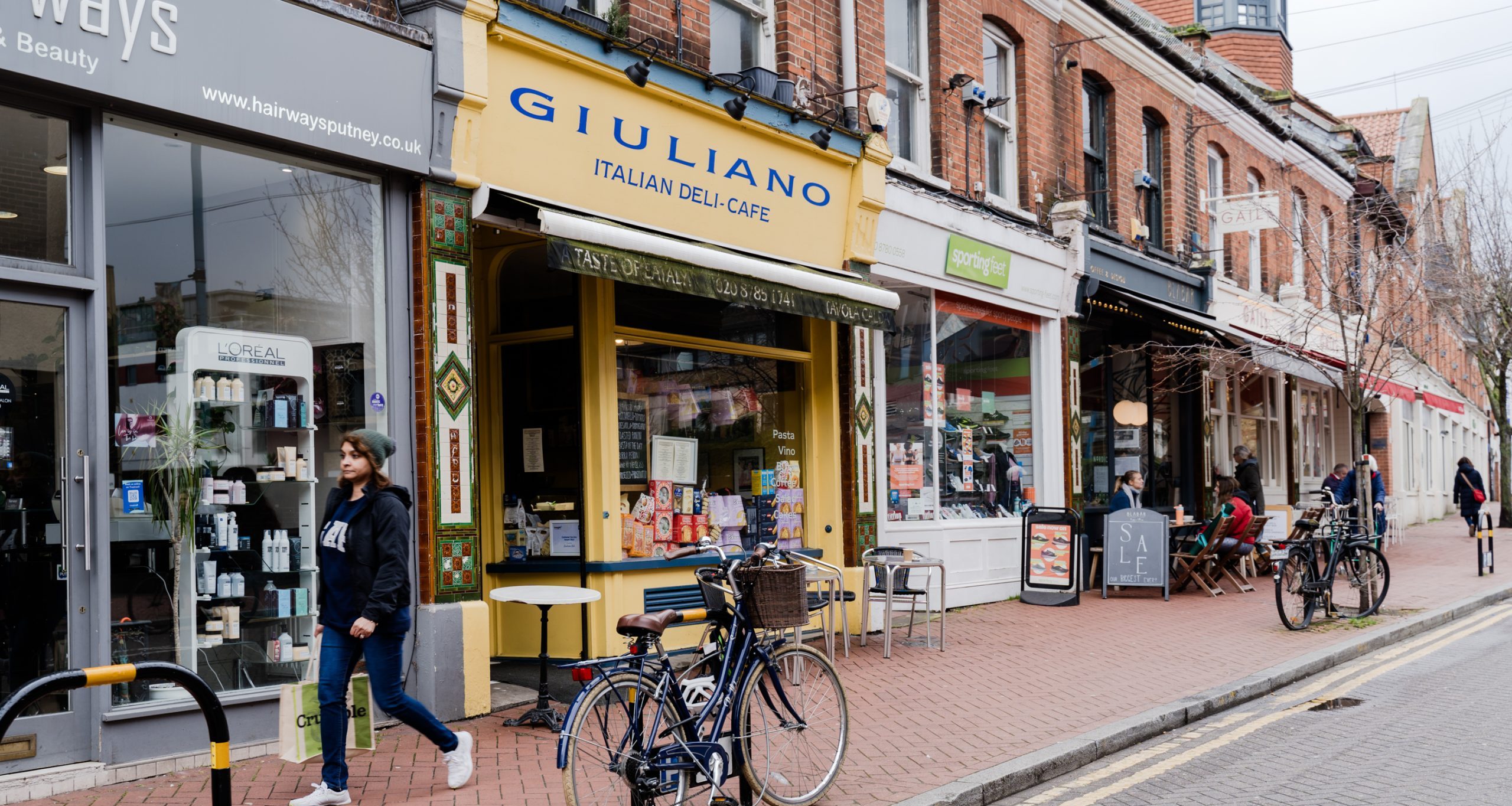 Photography of lacy road in Putney showing giuliano deli cafe, sporting feet, blabar, hairways and gails shopfronts.